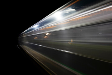 long exposure taken during night of a moving train ascending from the platform 