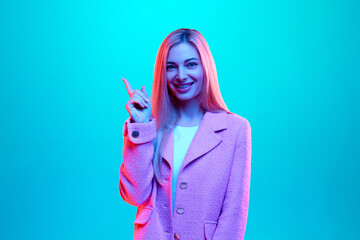 Young beautiful businesswoman raising finger up meaning ideas and thoughts against gradient pink...