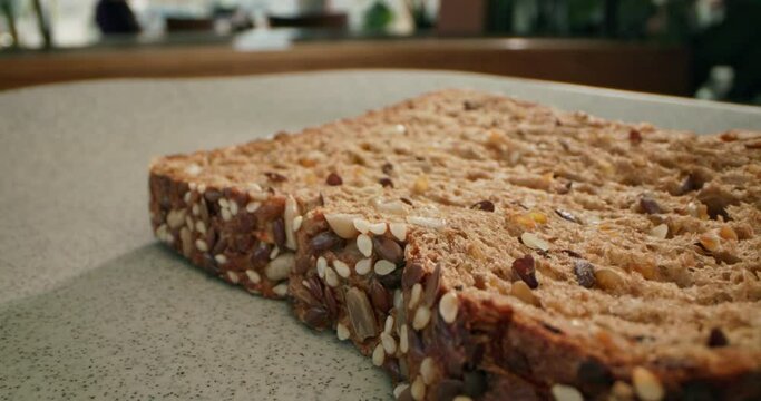Close-up of a piece of bread falling on the table. Making sandwiches for breakfast. High quality 4k footage