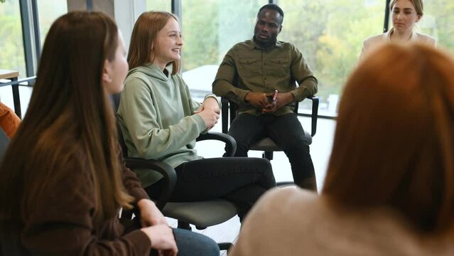 Diverse people talking sit in circle at group counseling therapy session concept, multiracial patients communicating sharing problems get support at rehab meeting.