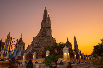 scenery sunset behind the large illuminated temple Wat Arun the biggest and tallest pagoda in the world beside Chaophraya river Bangkok, Thailand..pagoda in golden sunset popular landmark in Bangkok