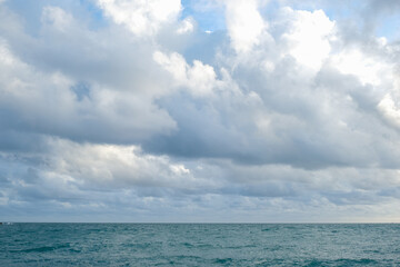 Tropical sea beach wave against blue sky with fluffy cloud