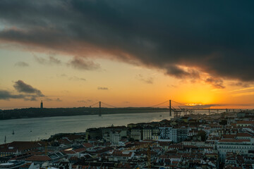 Lisbon at sunset, cityscape with orange sky and dark clouds
