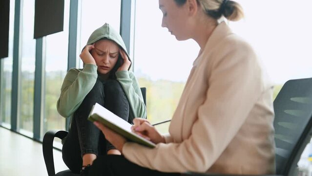 mental health and people concept - psychologist talking to stressed woman patient at psychotherapy session.