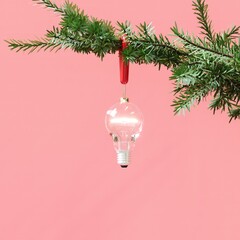 Closeup Light bulb Christmas decoration hanging on Christmas tree on Pink background. 3D Rendering Christmas concept idea.