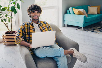 Photo of cheerful successful man sitting in comfort armchair working studying from home modern interior indoors - obrazy, fototapety, plakaty