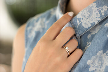 A gold ring with white stones on a woman's hand