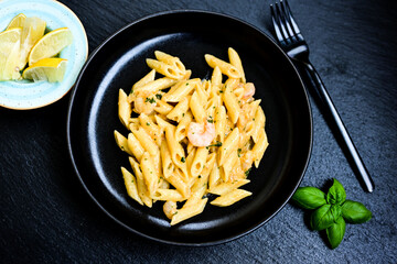  Italian home made   pennette pasta with smoked salmon , creamy sauce and fresh dill on wooden background