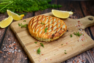 Tasty smokend  salmon  and broccoli pie . Salmon in puff pastry.. Home made healty  quiche ,lemon  and fish on wooden background