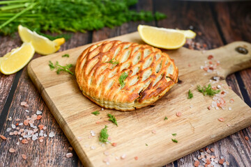 Tasty smokend  salmon  and broccoli pie . Salmon in puff pastry.. Home made healty  quiche ,lemon  and fish on wooden background