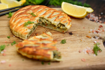 Tasty smokend  salmon  and broccoli pie . Salmon in puff pastry.. Home made healty  quiche ,lemon  and fish on wooden background