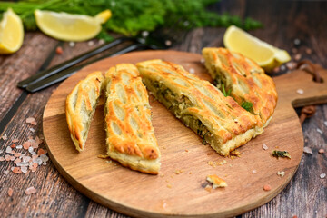  Tasty smokend  salmon  and broccoli pie . Salmon in puff pastry.. Home made healty  quiche ,lemon  and fish on wooden background