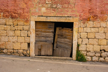 Fototapeta na wymiar An old wooden door in an historic abandoned stone house in Milna Village on the west coast of Brac Island in Croatia