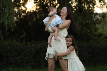Naklejka na ściany i meble The candid joy in a mother's eyes as she interacts with her children in the great outdoors, underscores the importance of family time and the instinctual bond of motherhood.