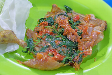 Ayam penyet: Indonesian spicy fried chicken served with cucumber and green tomato