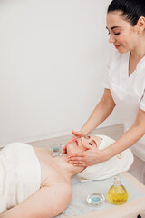 Obraz na płótnie Canvas Female masseur doing therapeutic facial massage in spa