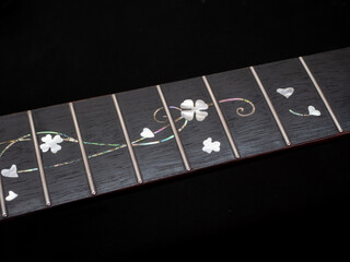 close up shot finger board  pearl inlay , heart and flower , acoustic guitar