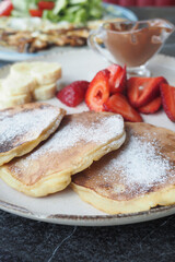 Tasty meal with berries and pan cake in bowl on black background