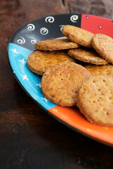 Homemade cookies on a colorful plate and wooden table with shallow depth of field.