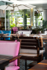 Hotel restaurant space with tables set for dinner at luxury resort, view through by window.