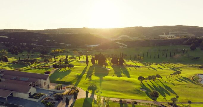 Aerial view cinematic video of the golf course. Playing golf in a beautiful landscape of palm trees and lakes, sports and nature. High quality 4k footage