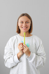 Health care dentistry and oral hygiene concept. Smiling young woman holds dental floss, toothbrush and interdental brush to for prevent oral disease. Daily routines caries prevention