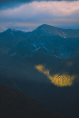 The ray of light hitting the side of a rocky mountain. Cloudy weather after a summer storm in the Carpathian Mountains of Romania © badescu