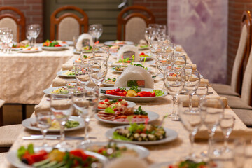 Served festive table with snacks, glasses, glasses, cutlery and napkins for a banquet