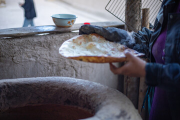 a traditional way of cooking bread in Central Asia Uzbekistan, Khiva, the Khoresm agricultural...