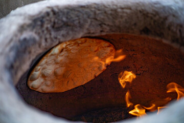 a traditional way of cooking bread in Central Asia Uzbekistan, Khiva, the Khoresm agricultural oasis, Citadel.