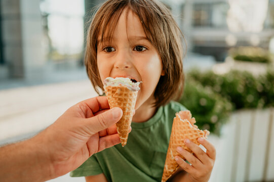 Father's hand feeding ice cream to son