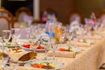 Served festive table with snacks, glasses, glasses, cutlery and napkins for a banquet