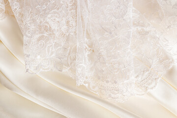 part of a beautiful beige lace tulle fabric or part of a bride's wedding dress on a beige satin...