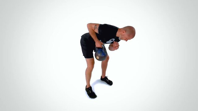 Trainer Performing the Single Kettlebell Bent-Over Row Exercise On White Background Side View