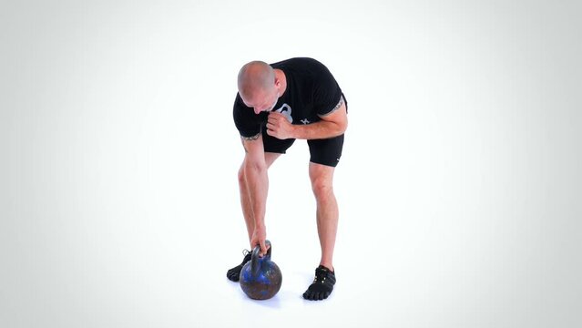 Trainer Performing the Kettlebell Bent-Over Row Exercise On White Background Side View