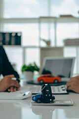 A car dealer with a customer, the new owner, signs a lease-purchase document. car sales contract The employee explains the installment payment terms. vertical picture