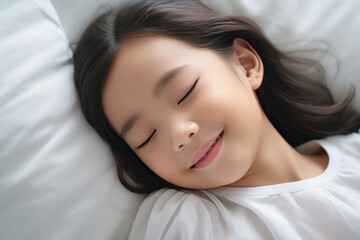 Fototapeta na wymiar Asian little girl sleeping well on white pillow in bed