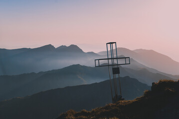 Cross on the top of the mountain at sunset. The Christian symbol of faith in God
