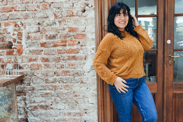 young woman leaning against restaurant wall posing pretending to be distracted