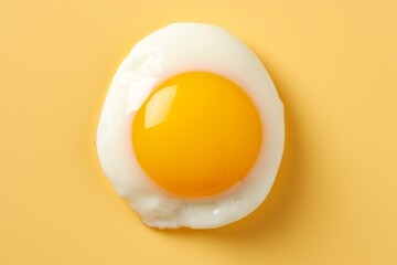 Delicious and mouthwatering fried egg isolated on a vibrant yellow background, top view