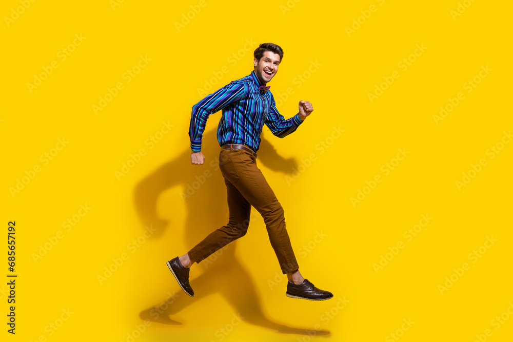Poster full size photo of good mood guy dressed striped shirt brown trousers run shopping to empty space is
