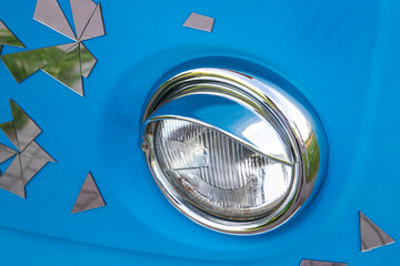Round headlight of blue retro car. Close up photo