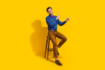 Fototapeta na wymiar Full size photo of pleasant guy dressed striped shirt indicating at profitable proposition empty space isolated on yellow color background
