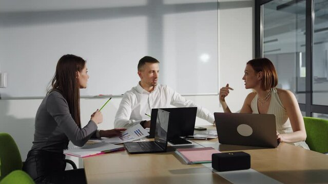 Meeting in the office of the head of the sales department. Three people in a meeting room