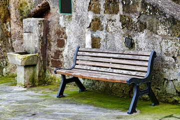 Ancient public drinking fountain and bench in the medieval town of Sovana Tuscany Italy