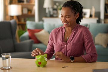 Happy woman putting coins in piggy bank- money saving concept