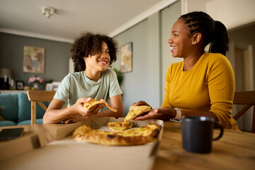 Mother and teenage son having pizza at home