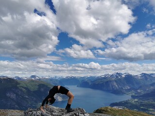 Bridge yoga pose on top of a mountain