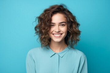 Fototapeta premium Portrait of a smiling young businesswoman with glasses on blue background
