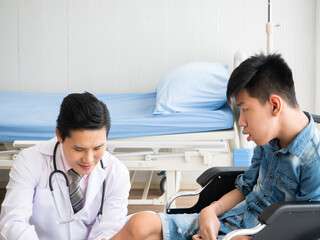Asian expert doctor gentle holding leg and explain about physical pain recovery plan to disabled...